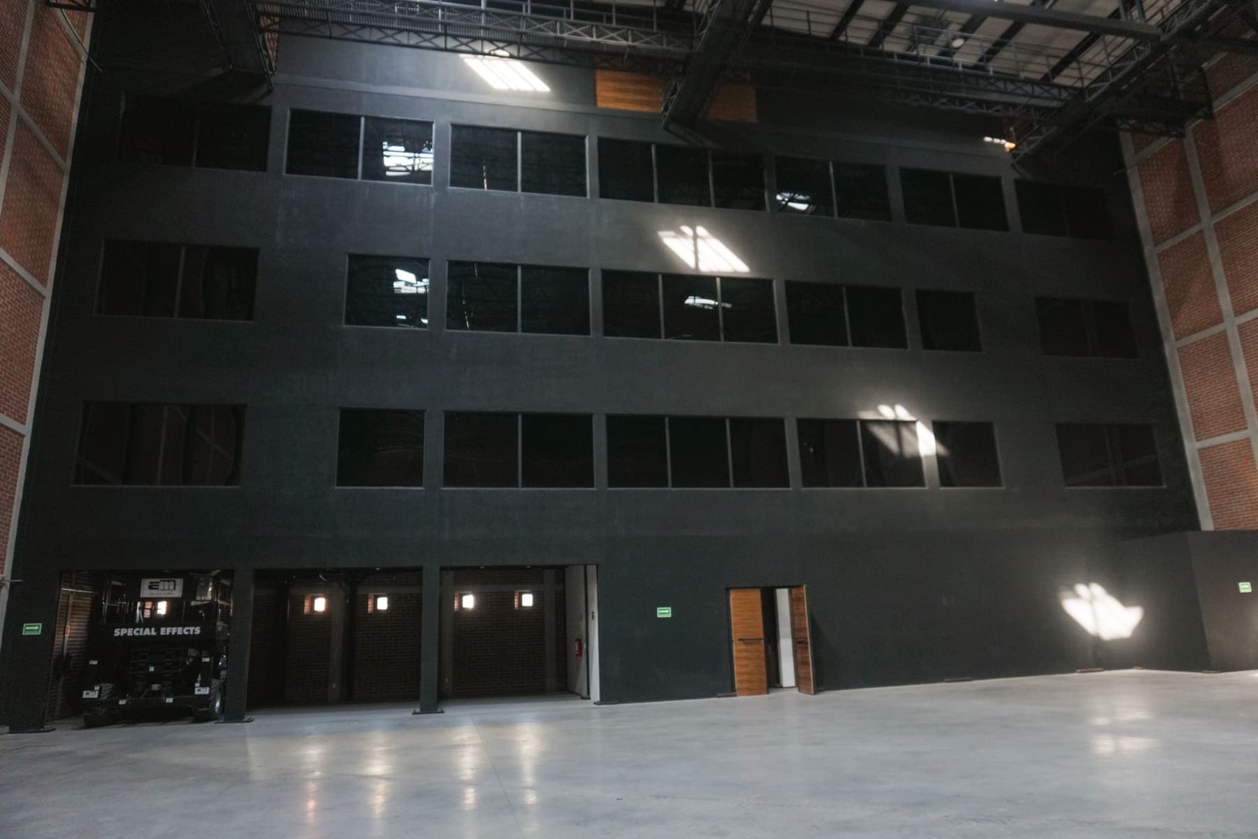 Bloque de cuatro niveles pintado de negro adosado a un extremo del espacio.