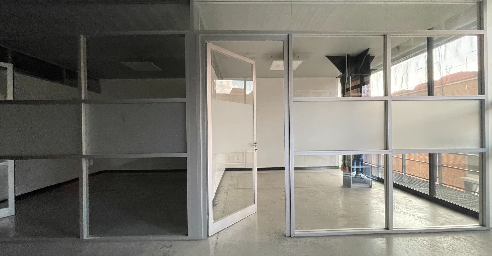 Oficinas divididas con cancelería de aluminio y cristal esmerilado.