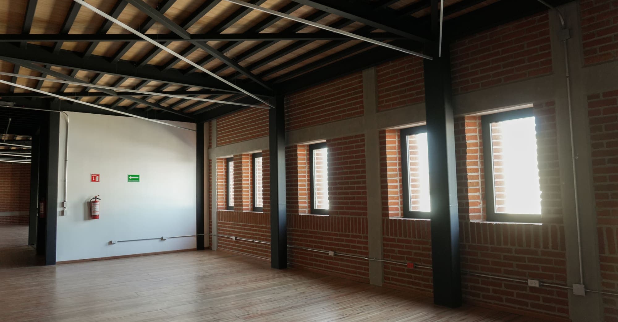 La sala de viga vista a lo largo, con la fila de ventanas y el muro de ladrillo.